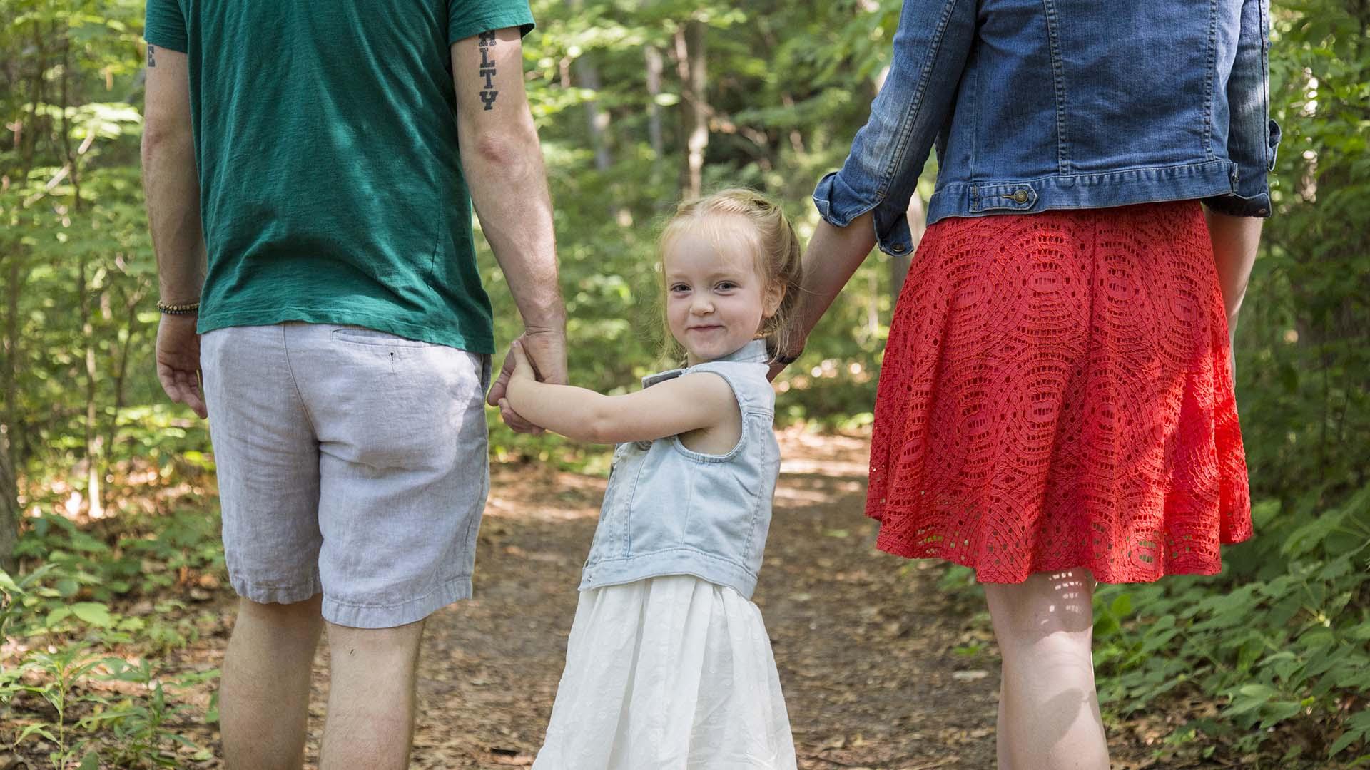 A family walking in the woods. 