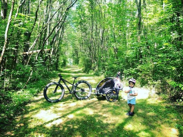 A child standing near a bike on a trail at Love Creek Nature Center.