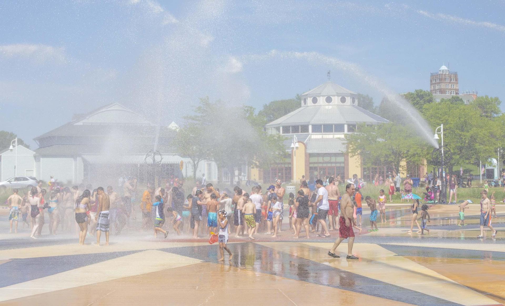 People enjoying the Whirlpool Compass Fountain on a summer day. 