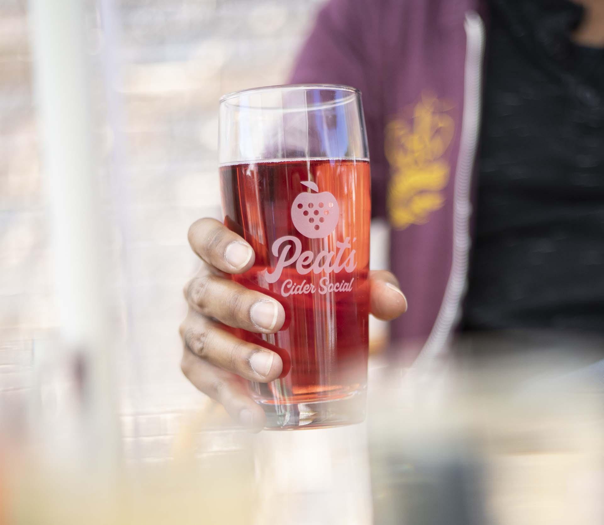 A person holding a cider at Peat