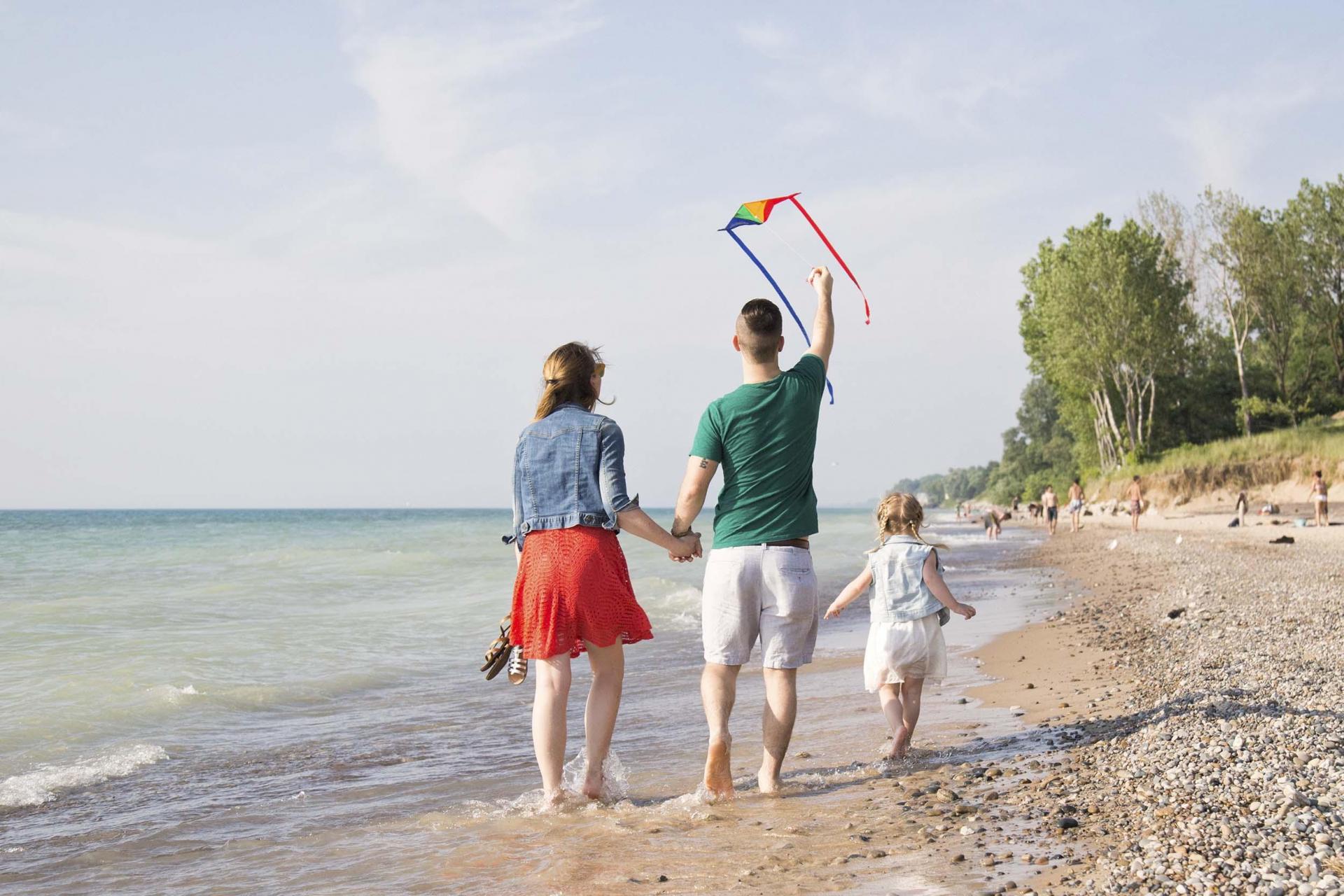 A family walking on the beach at Grand Mere State Park.
