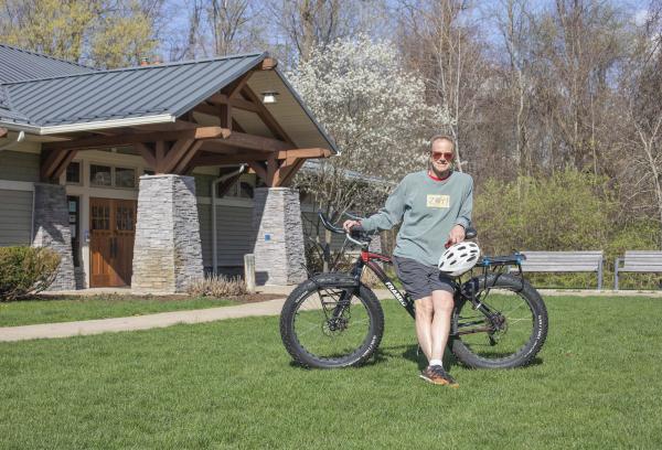 A man standing outside of Love Creek Nature Center with a bike.