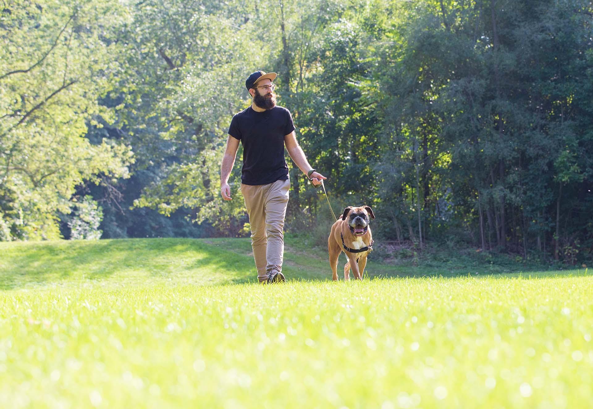 A man walking a dog at a park.
