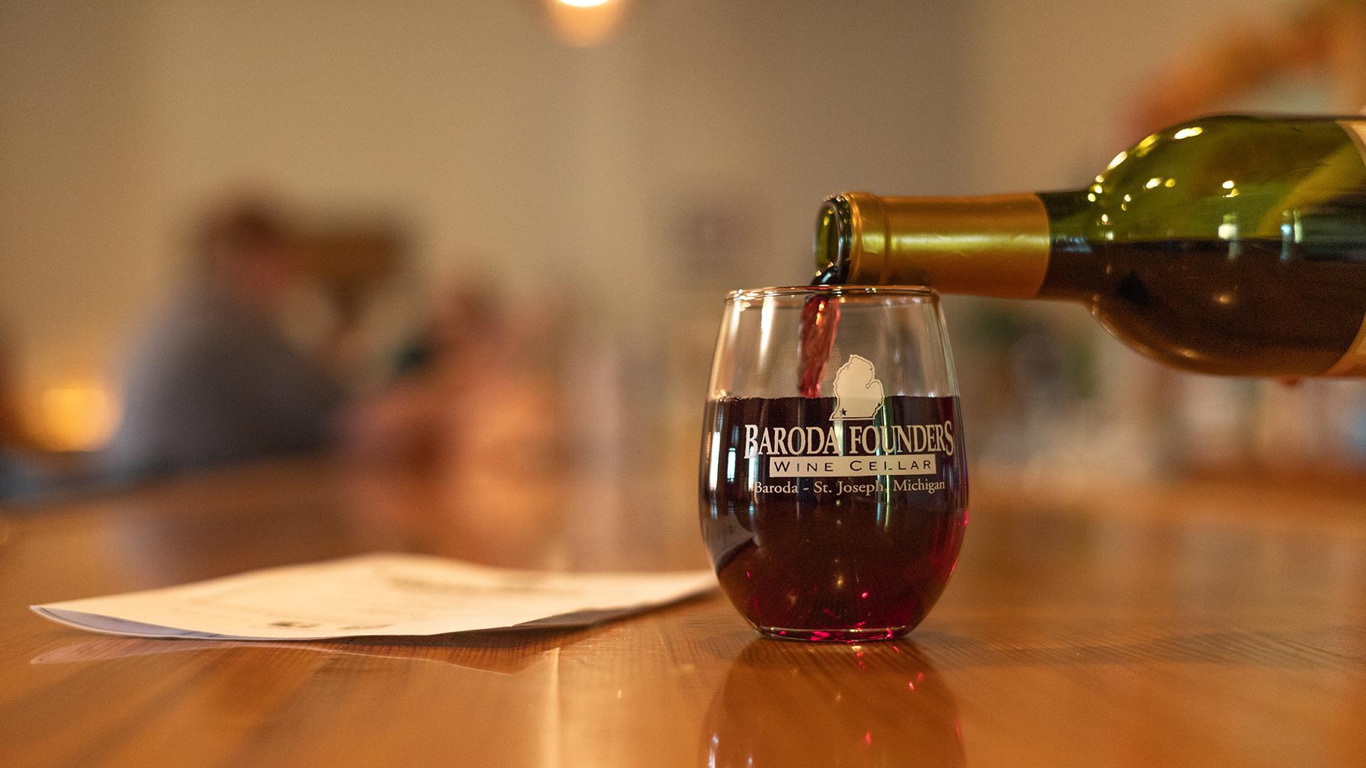A wine glass being filled with red wine