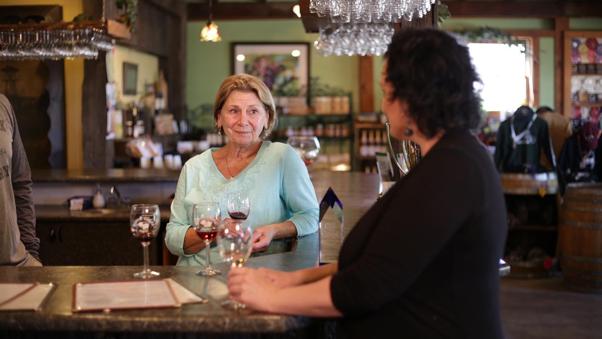 Two women at the tasting bar at Lemon Creek Winery