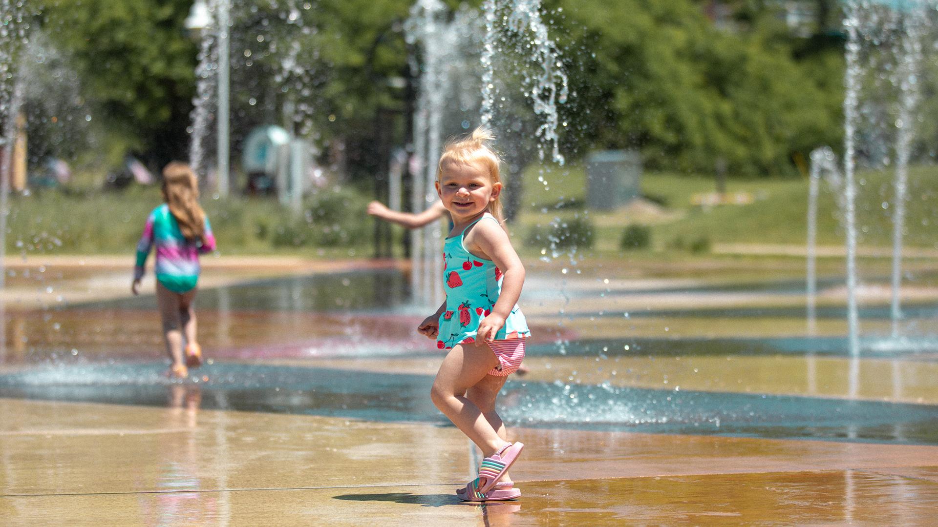 Children playing and splashing in the Whirlpool Compass Fountain, laughing as water jets sh_DrQ6