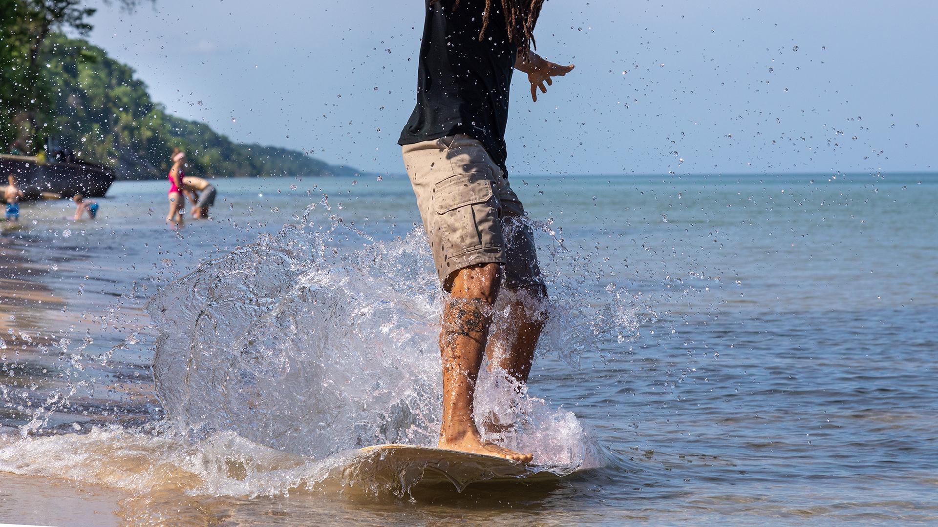 Riding a skimboard along Lake Michigan