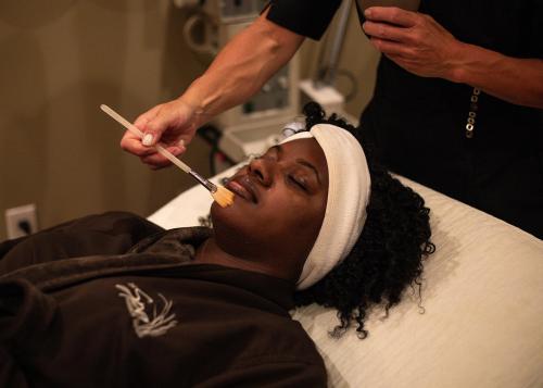 A woman enjoying a facial at the Inn at Harbor Shores, relaxing in a calm, spa-like setting