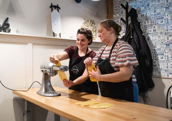 Two people participating in a cooking class at Culinary Cottage