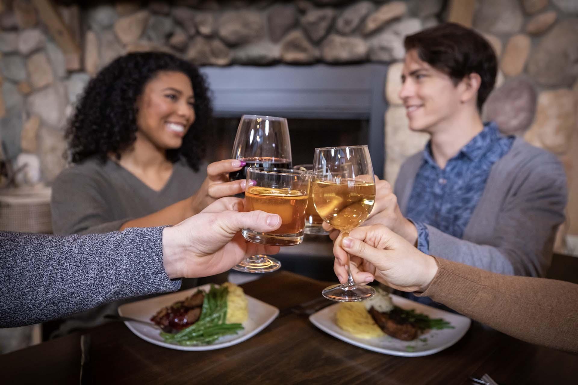 Four people enjoying drinks and a meal at Tabor Hill