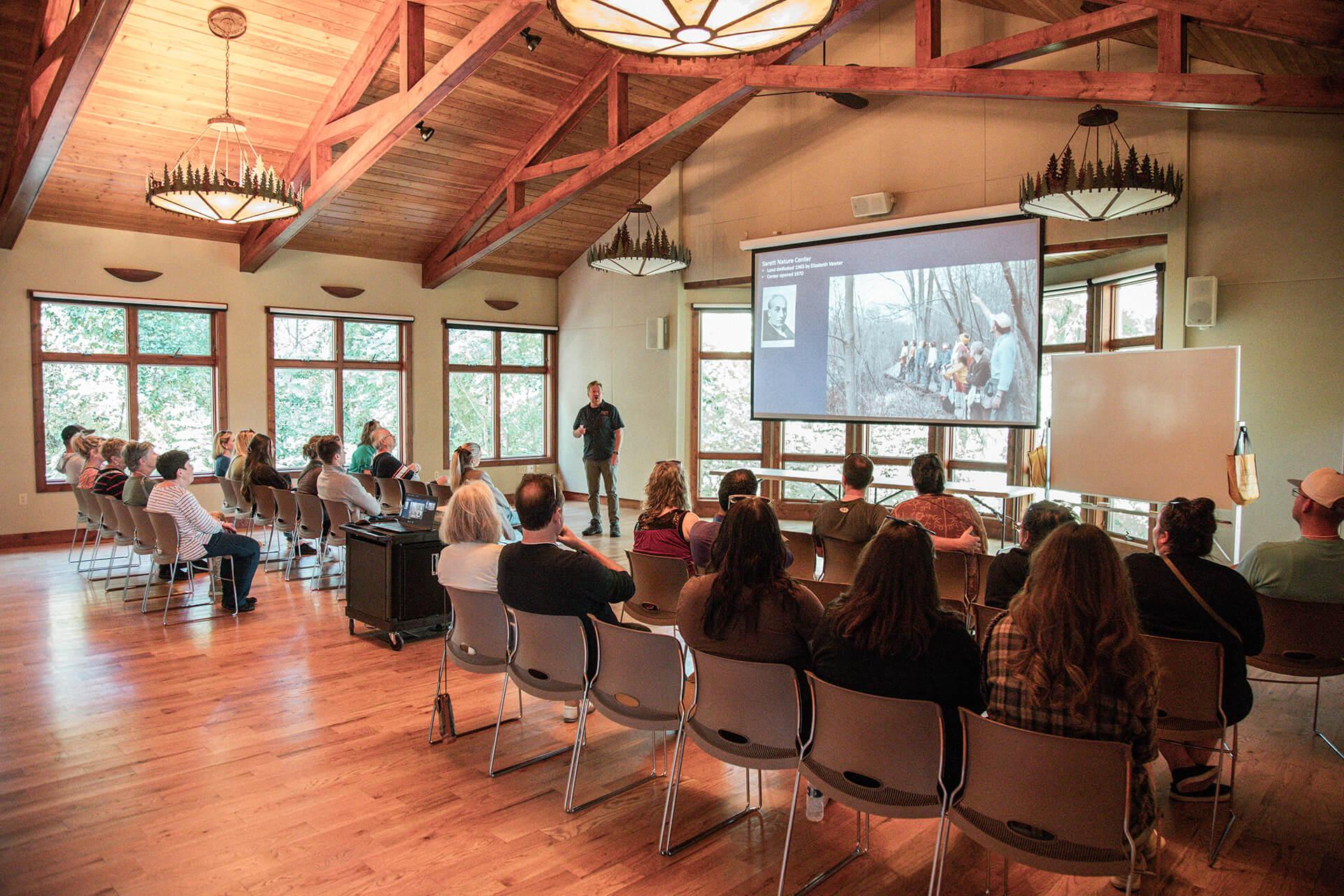 A group listens in as a naturalist shares the rich history of Sarett Nature Center in the event room.