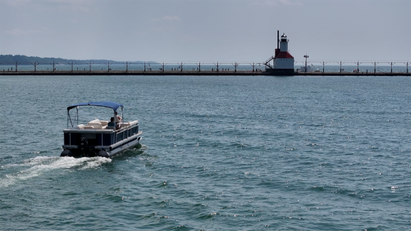 Pontoon boat driving on Lake Michigan near the St. Joseph lighthouse