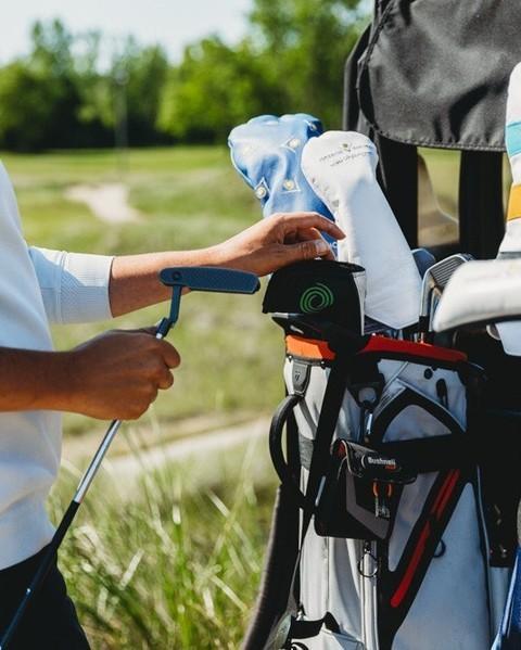 A person preparing their clubs for a round of golf at Harbor Shores.