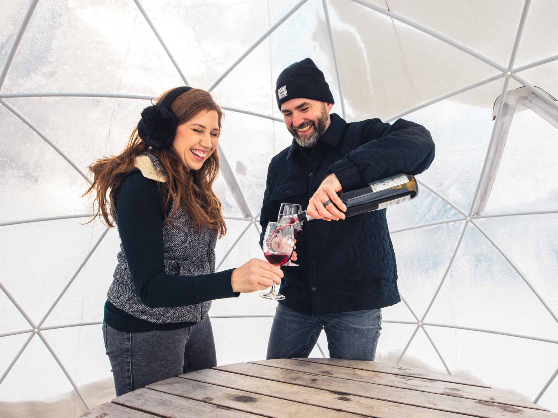 Two people enjoying wine in an igloo at Lemon Creek Winery.
