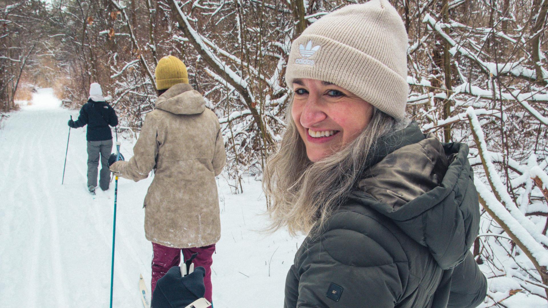 Cross country skiers make their way through a quiet forest path.