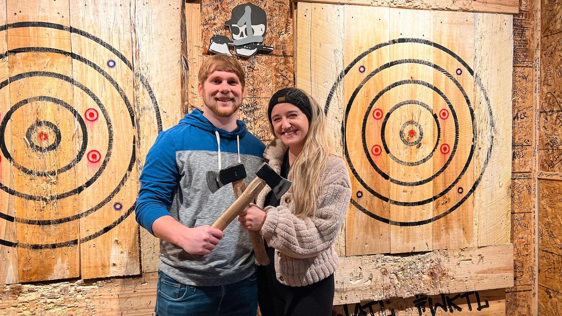 Friends pose with axes after a round at Lumberjax: Urban Axe Throwing.