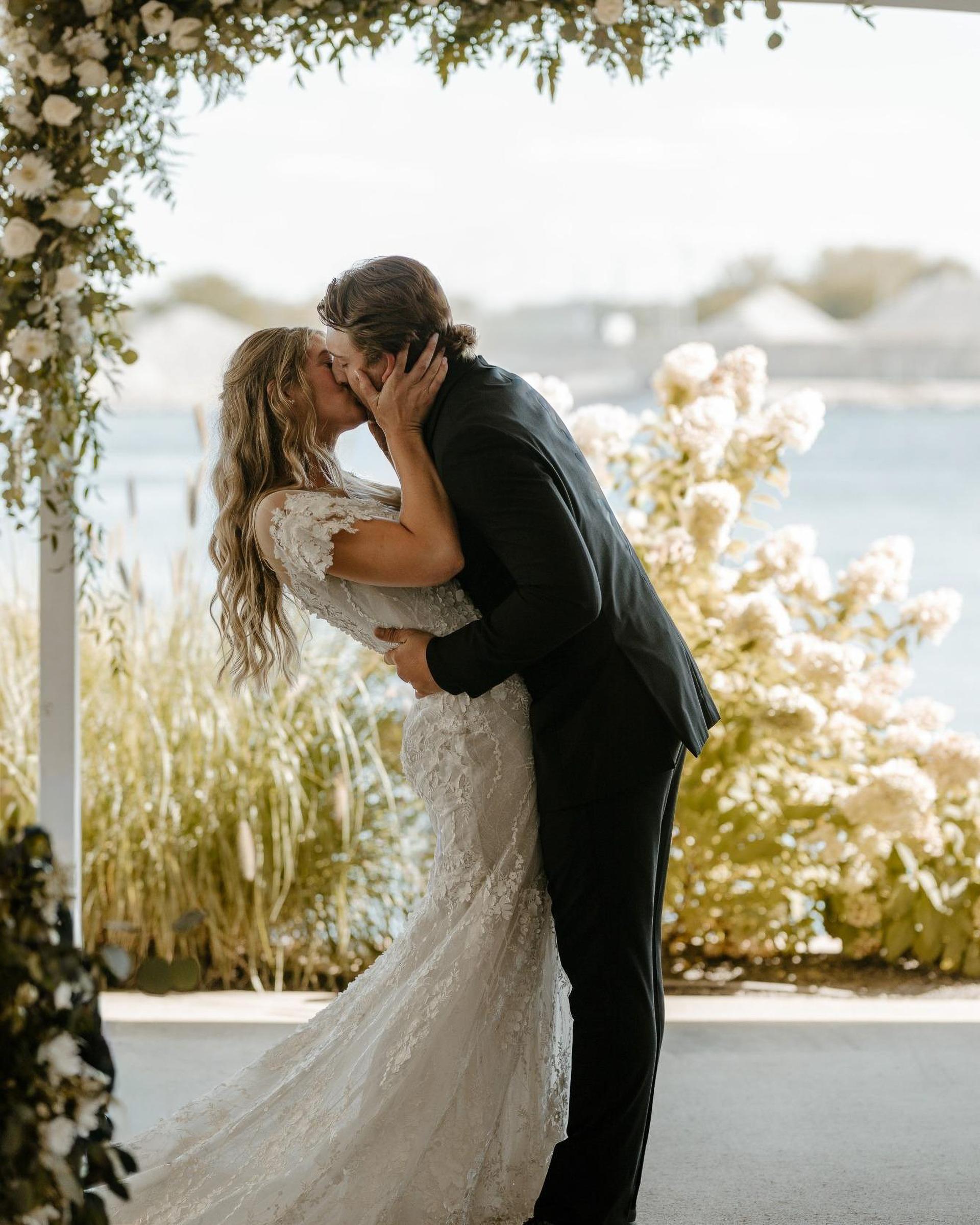 A bride and groom share a romantic kiss on their wedding day.