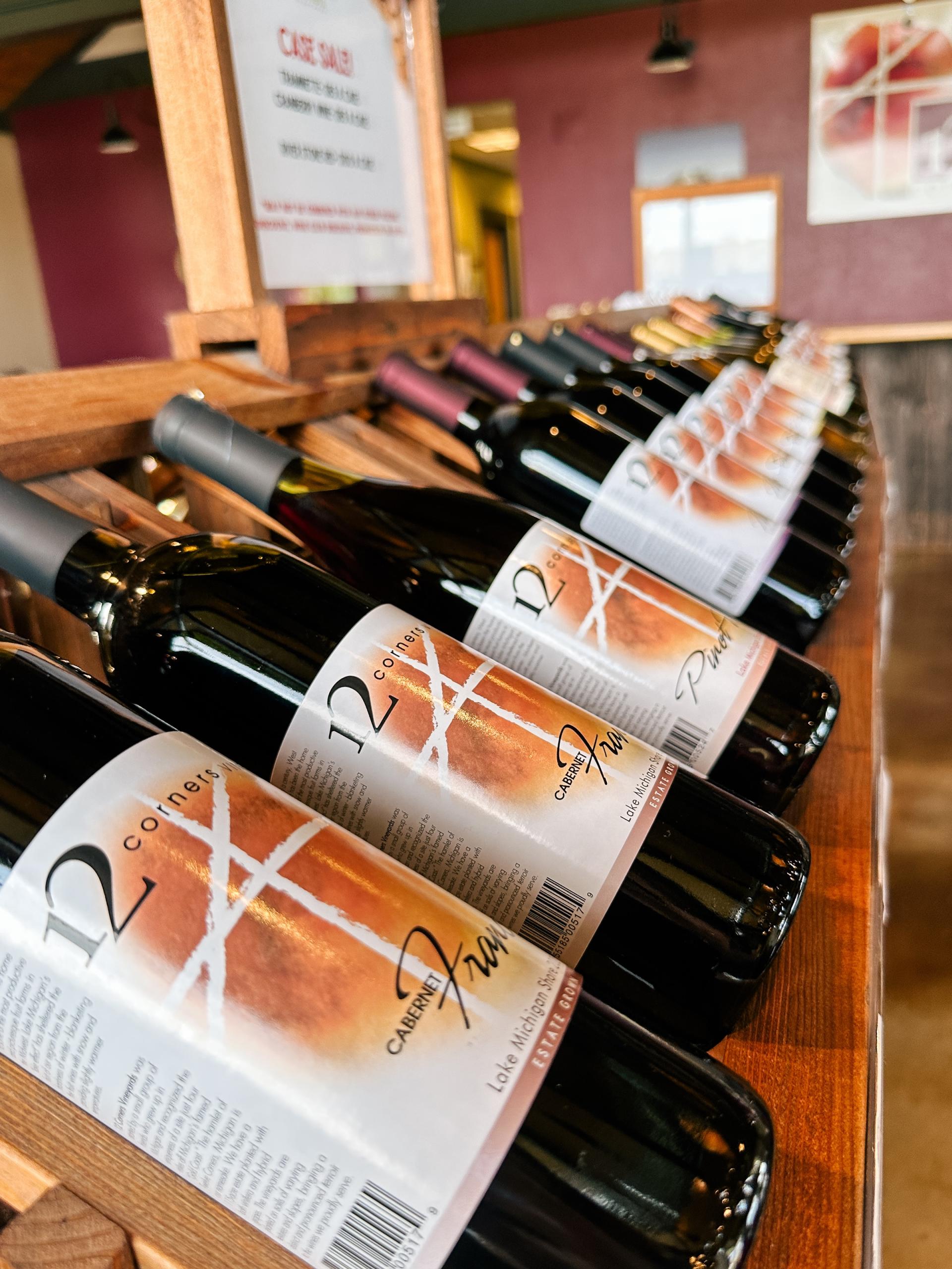Bottles lined up on a wine rack at 12 Corners Vineyards.