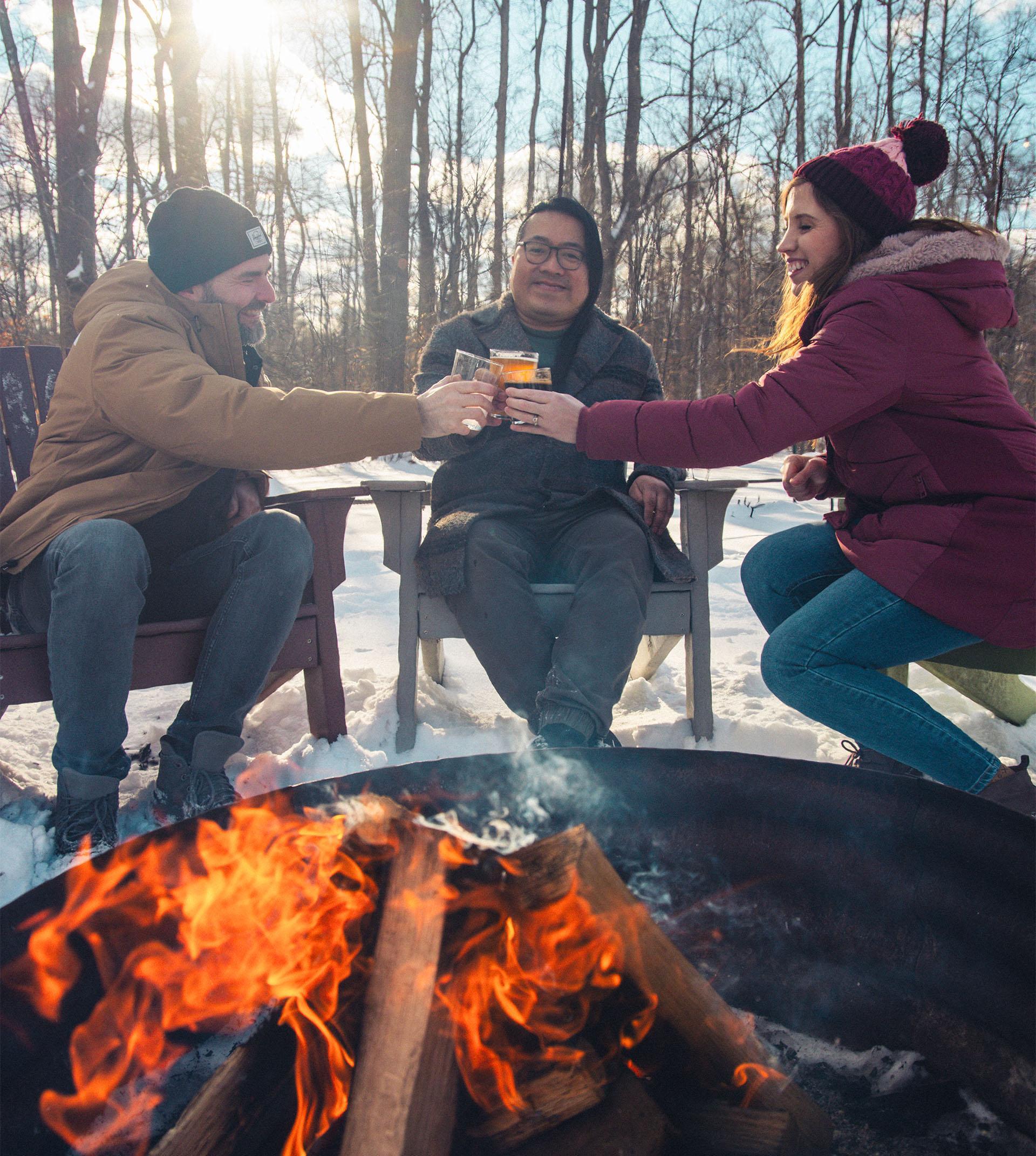 A group of friends share a cheerful moment near the fire at Haymarket Brewery.