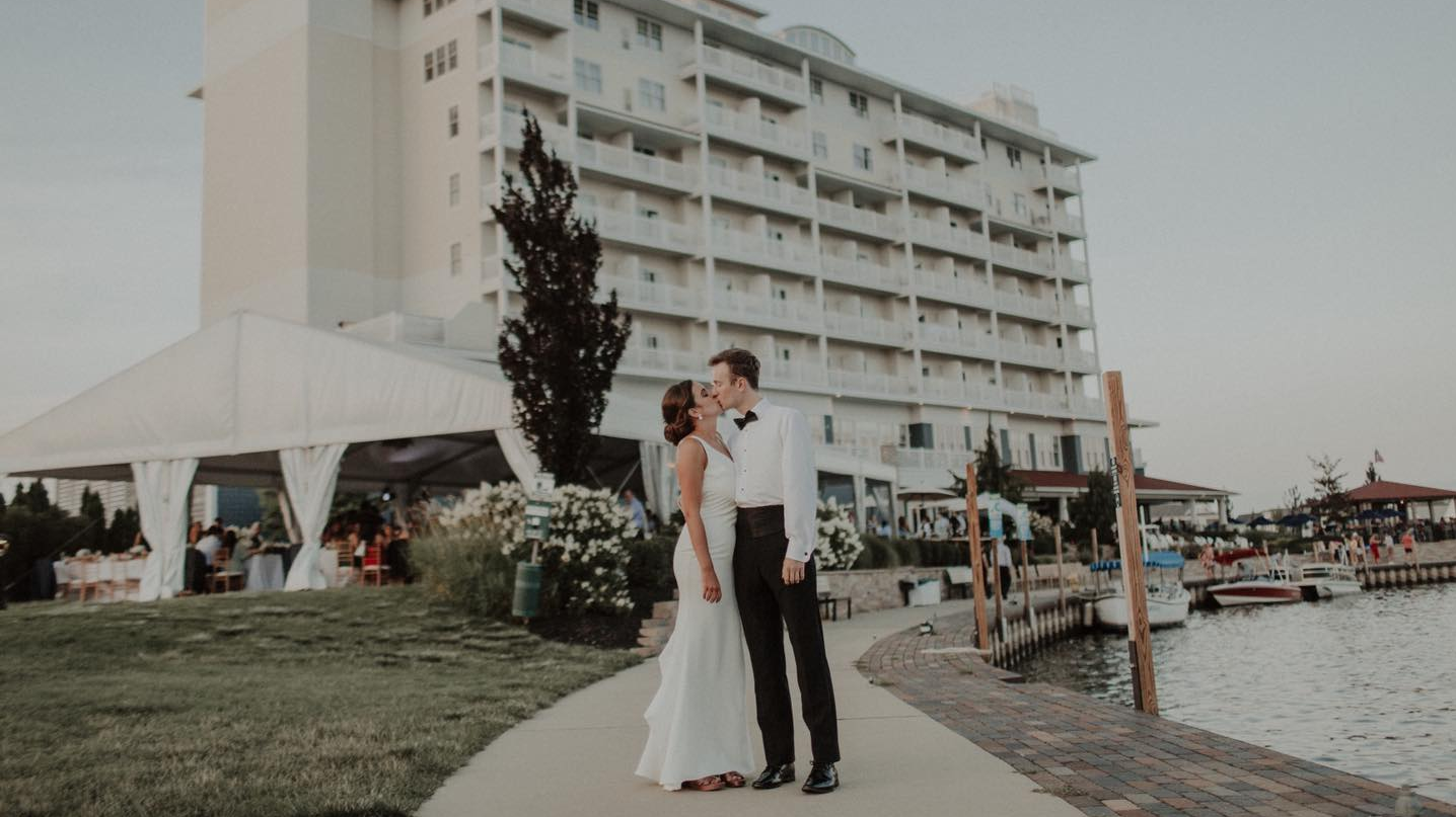 Bride and Groom kissing in front of the inn at Harbor Shores