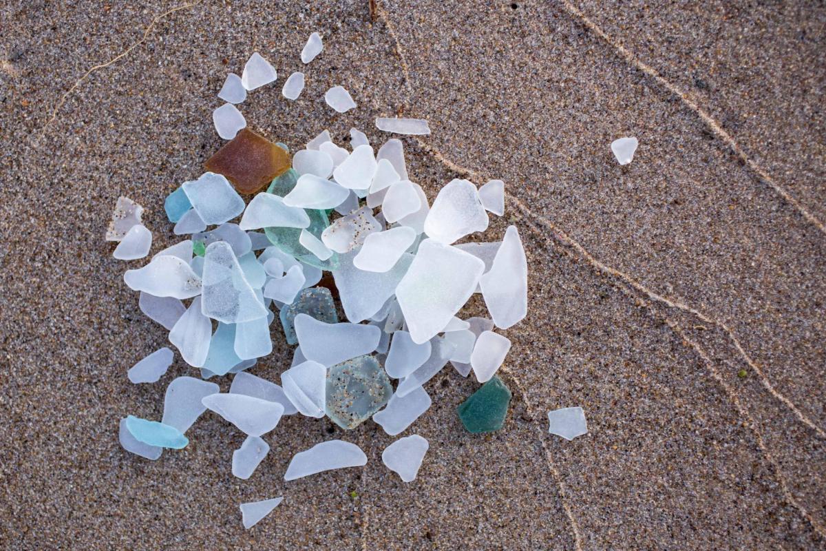 A pile of colorful beach glass on the sand.