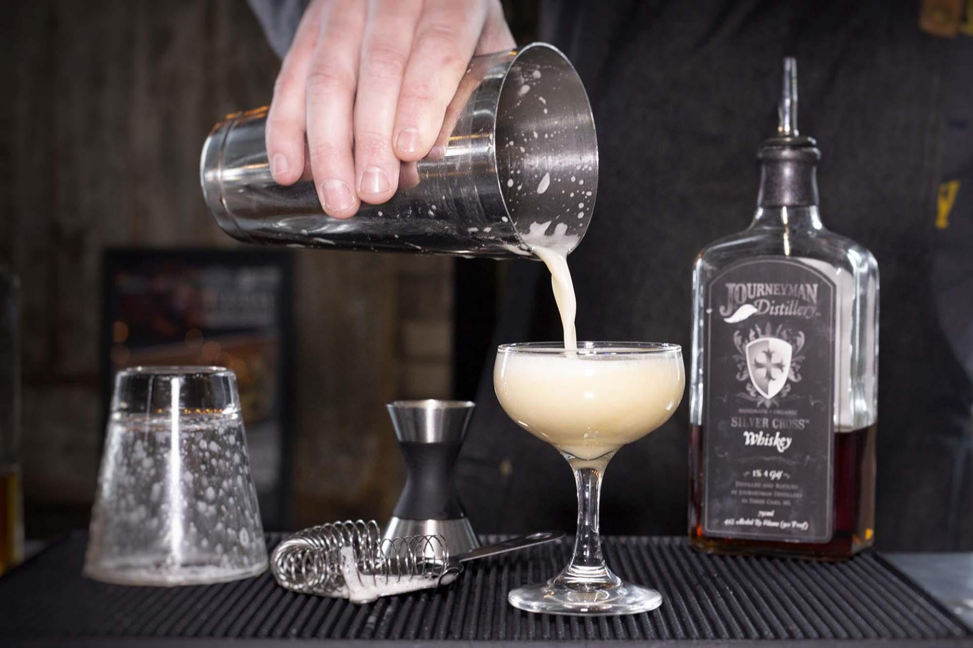 A cocktail being poured at Journeyman Distillery