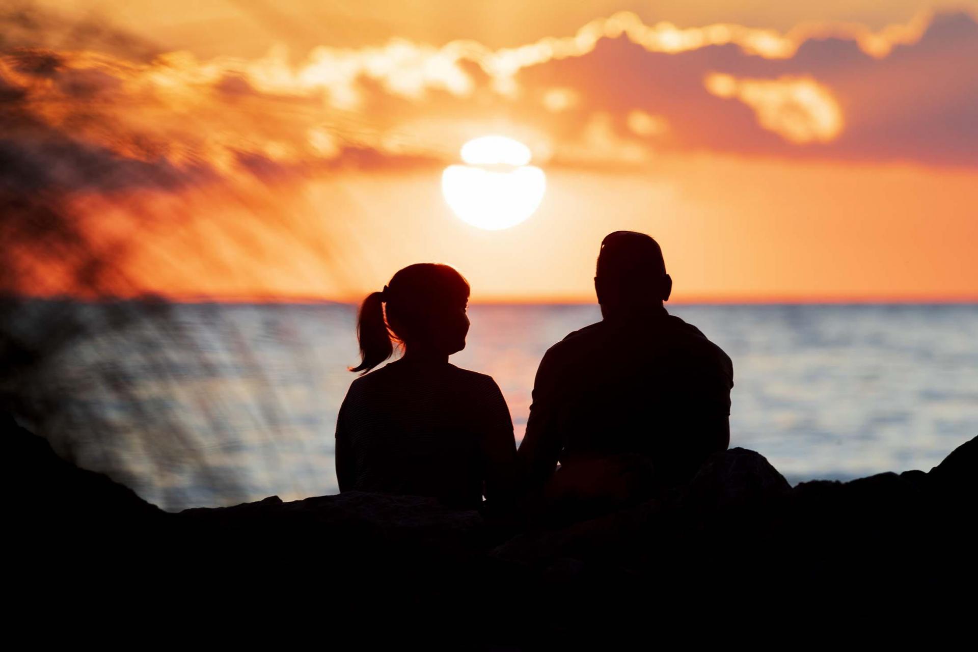 A couple enjoying a sunset at Silver Beach.