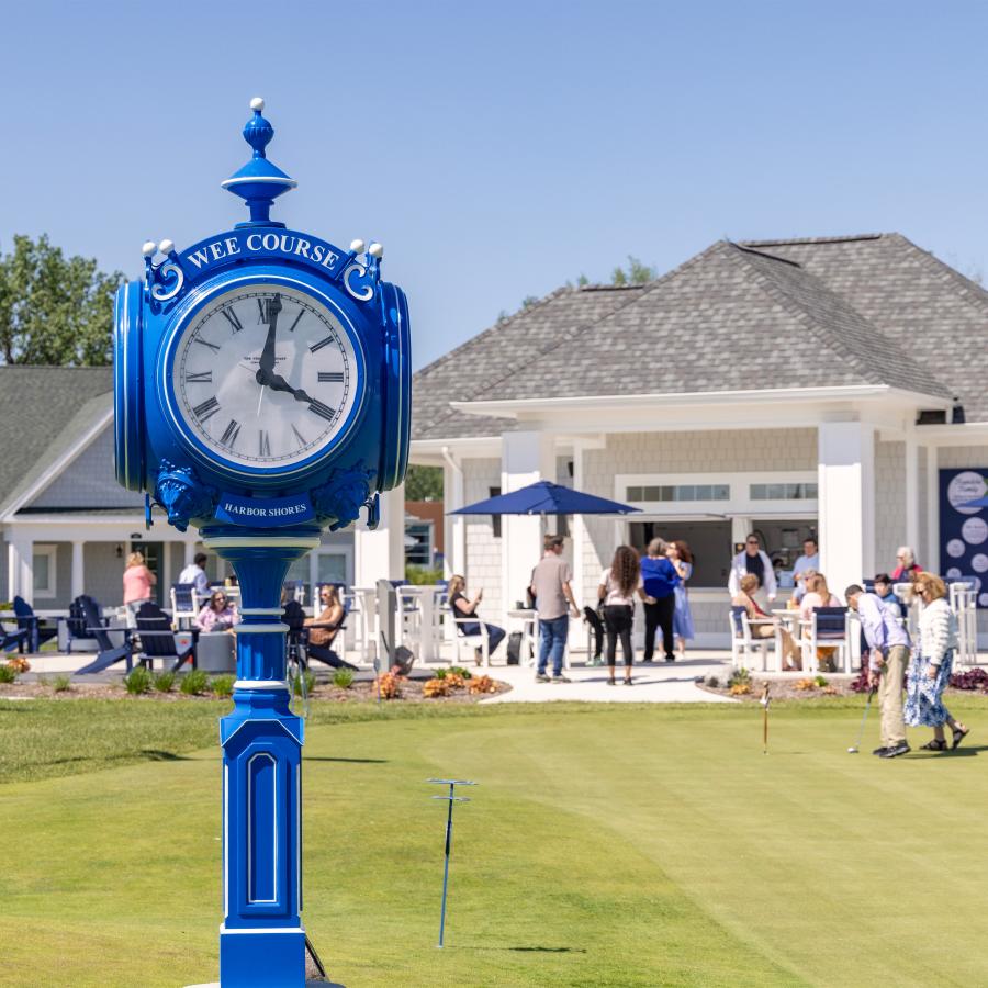 Focus of the clock at Wee Golf Course, course and people in the background