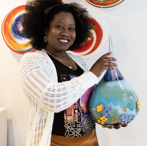 A person holding artwork at Water Street Glassworks.