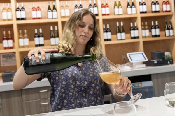 A Lake Michigan Vintners staff member pours a glass of wine.