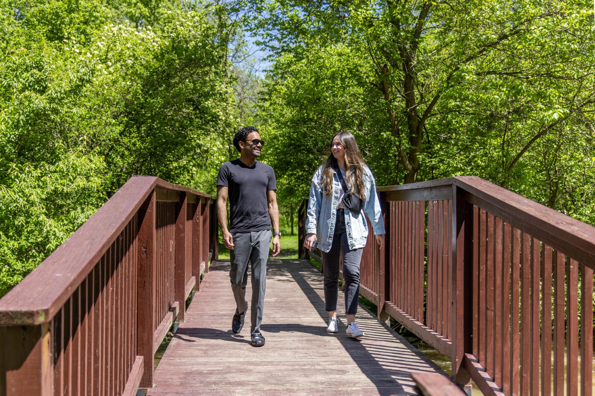 Two people crossing a bridge on foot at Flaherty Park.