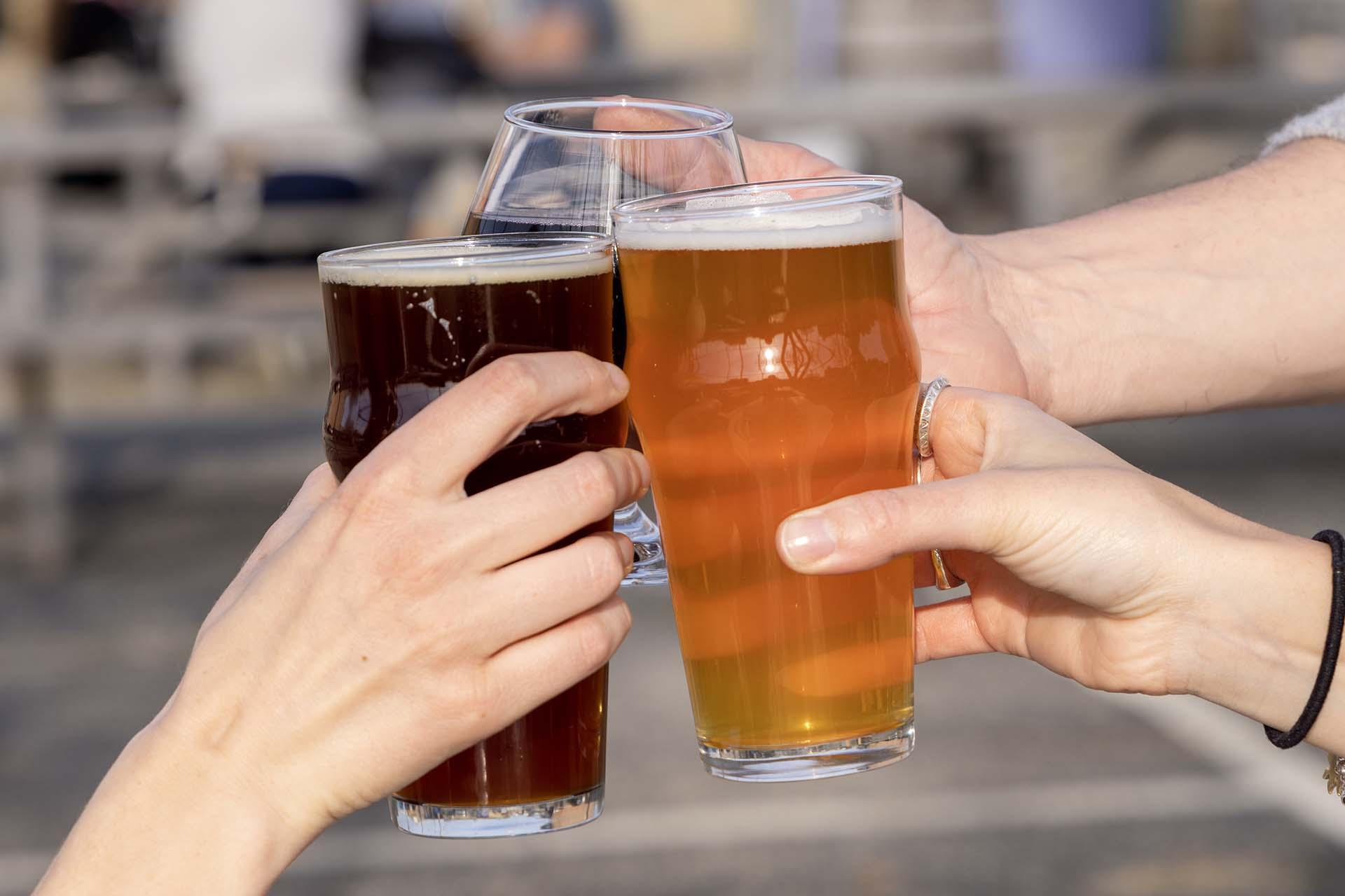 People holding beers at the Livery.