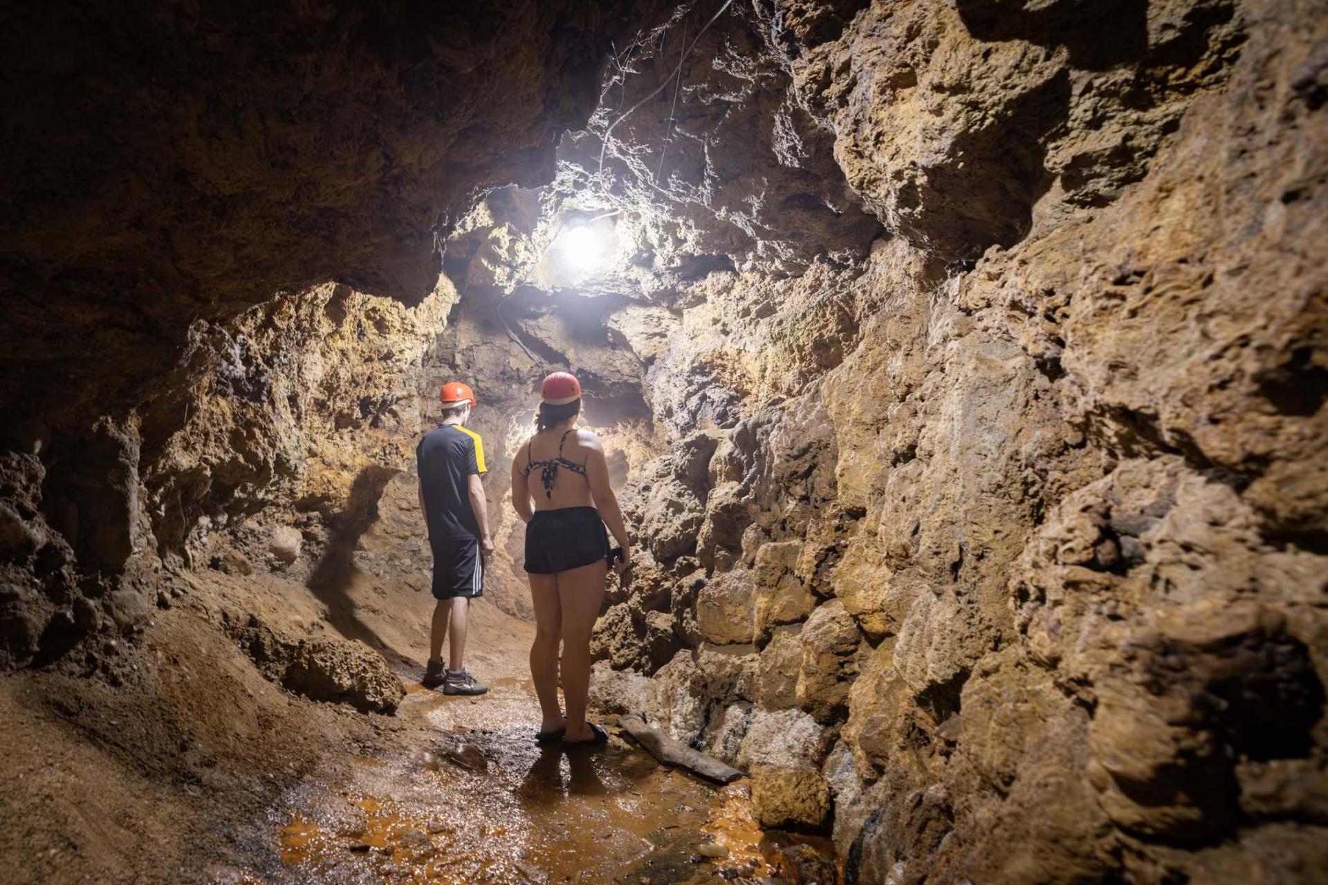 Two people exploring Bear Cave.