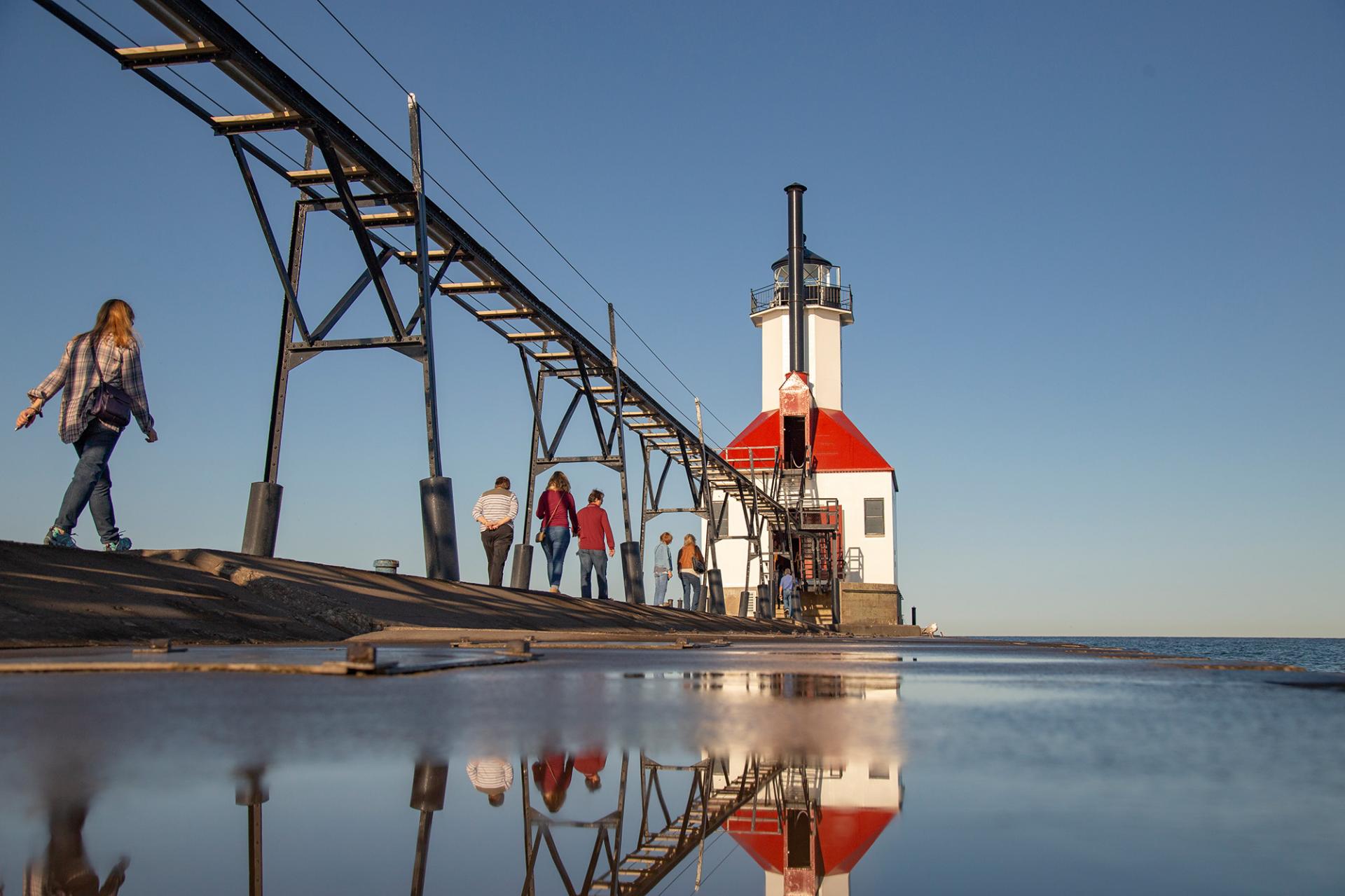 People walking into the St. Joseph Lighthouse while touring