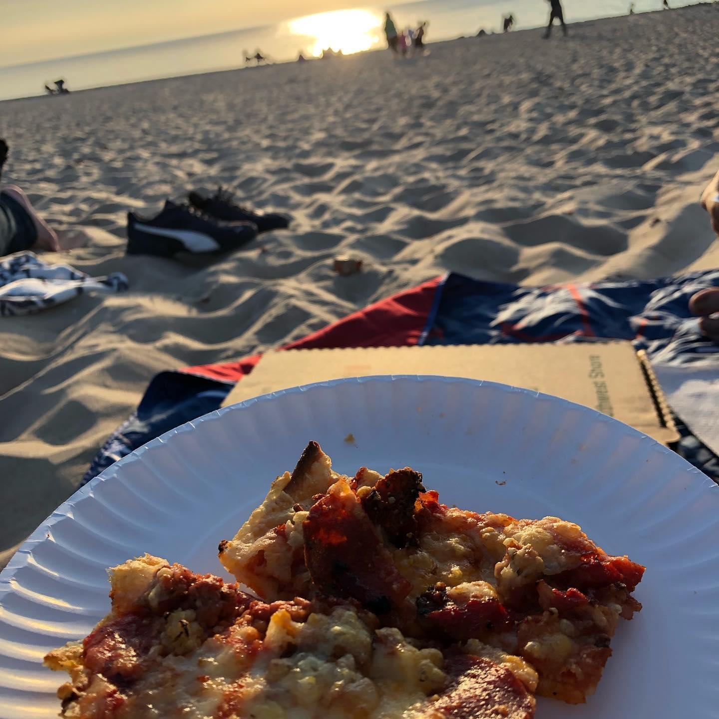 Pizza on a paper place on the beach