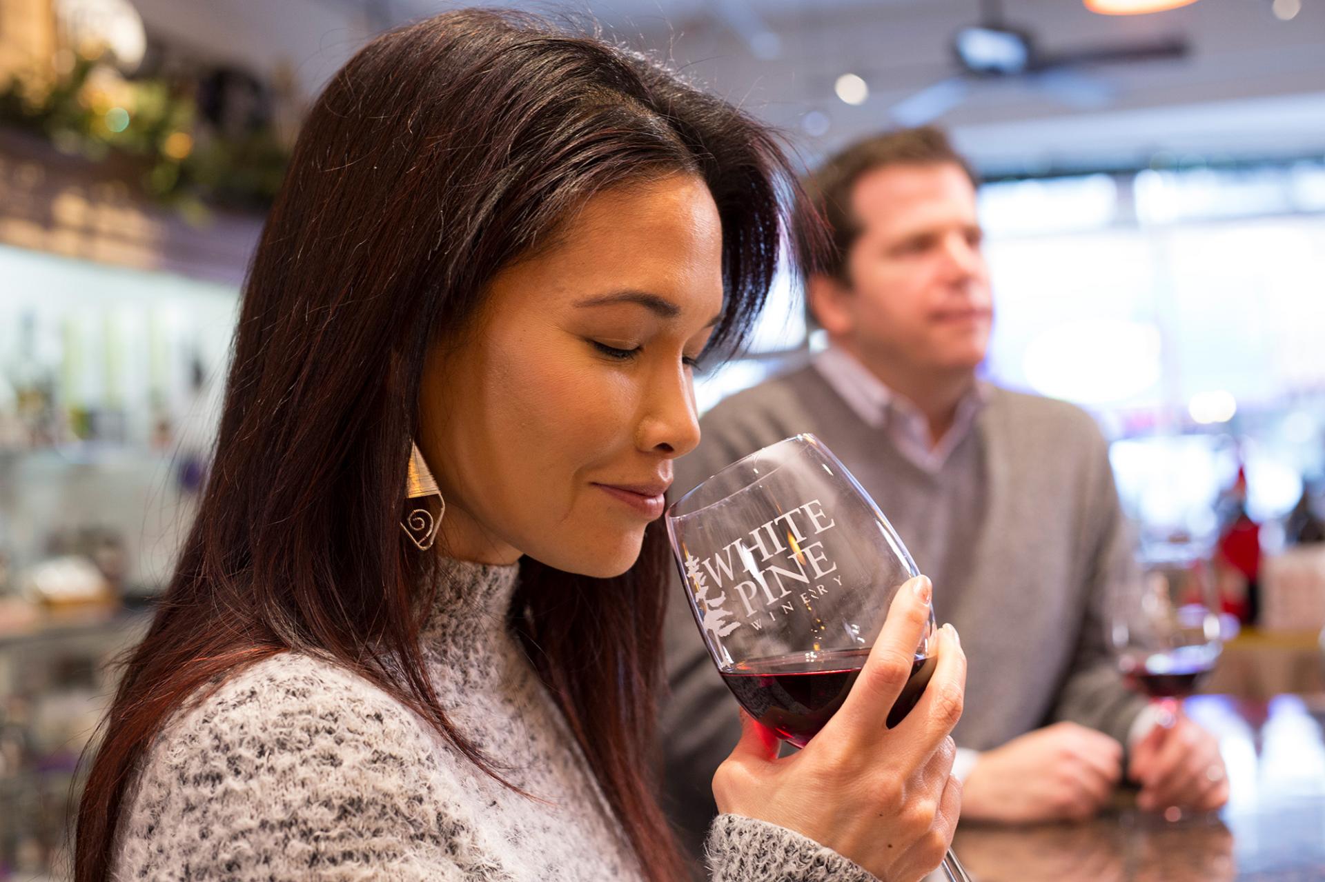 A woman sniffing a glass of wine