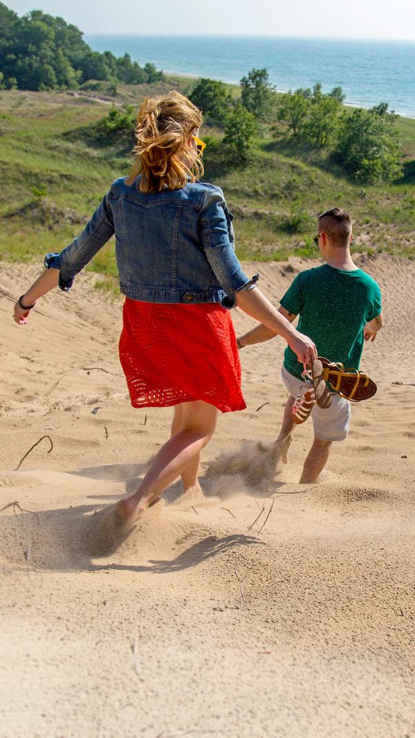 People walking down a dune at Grand Mere State Park