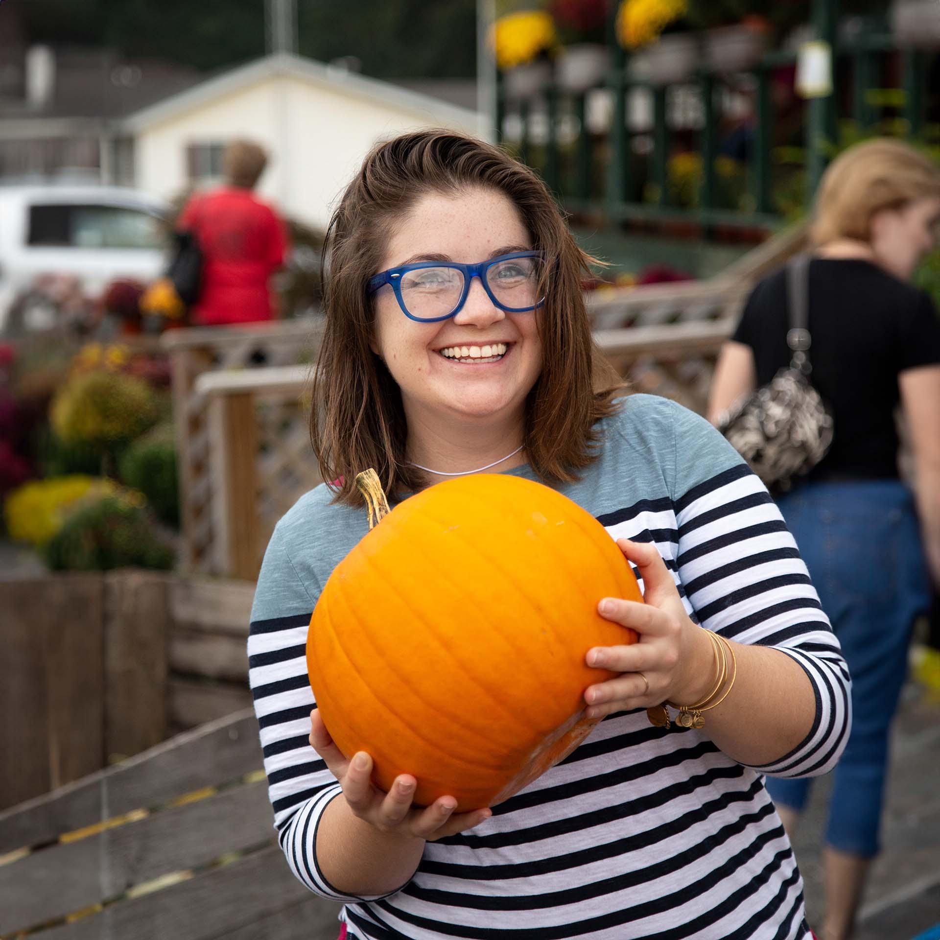 A person holding a pumpkin.
