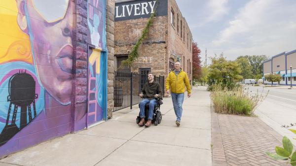 Two people walking past the Livery.