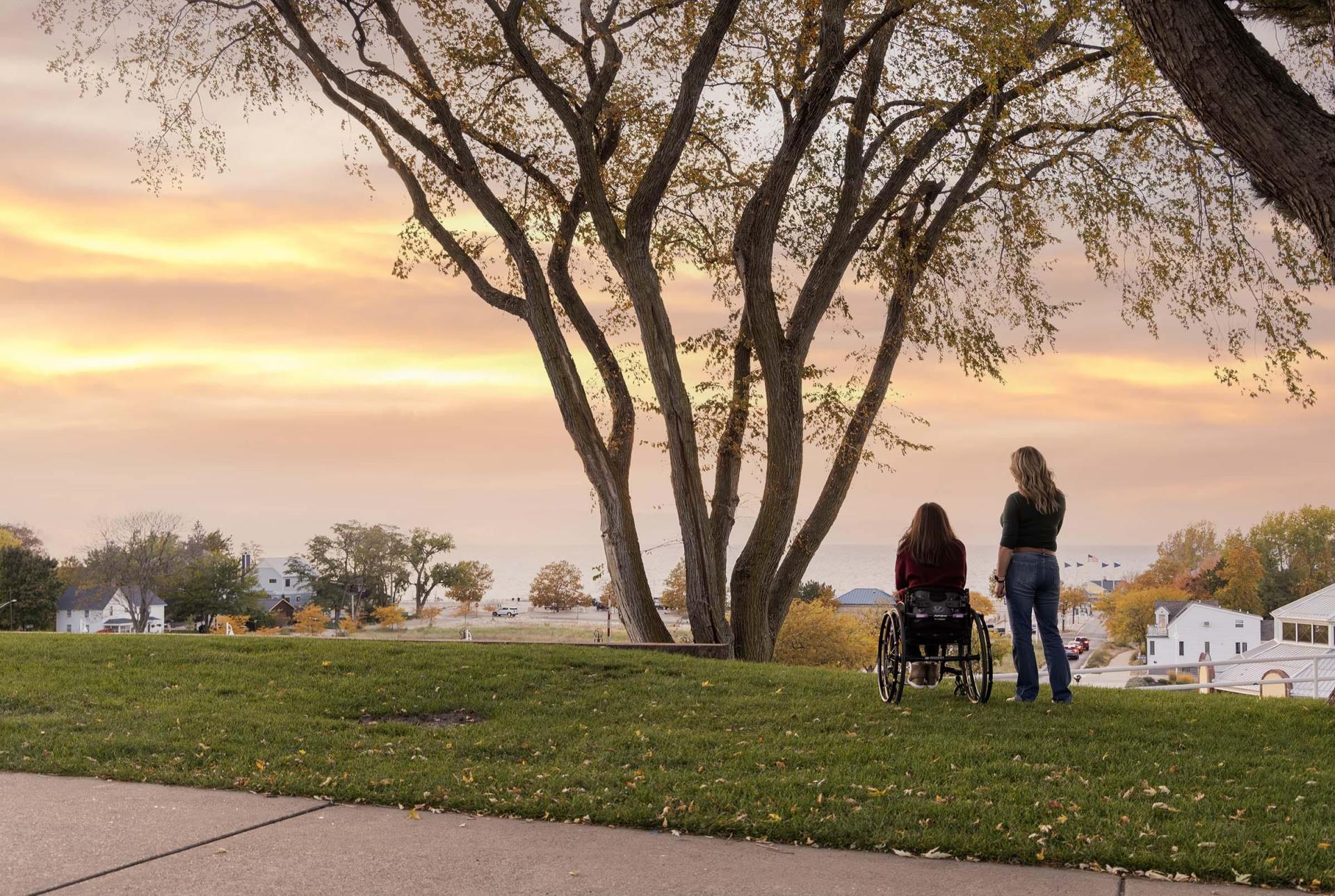 Two people enjoy the sunset from Lake Bluff Park.