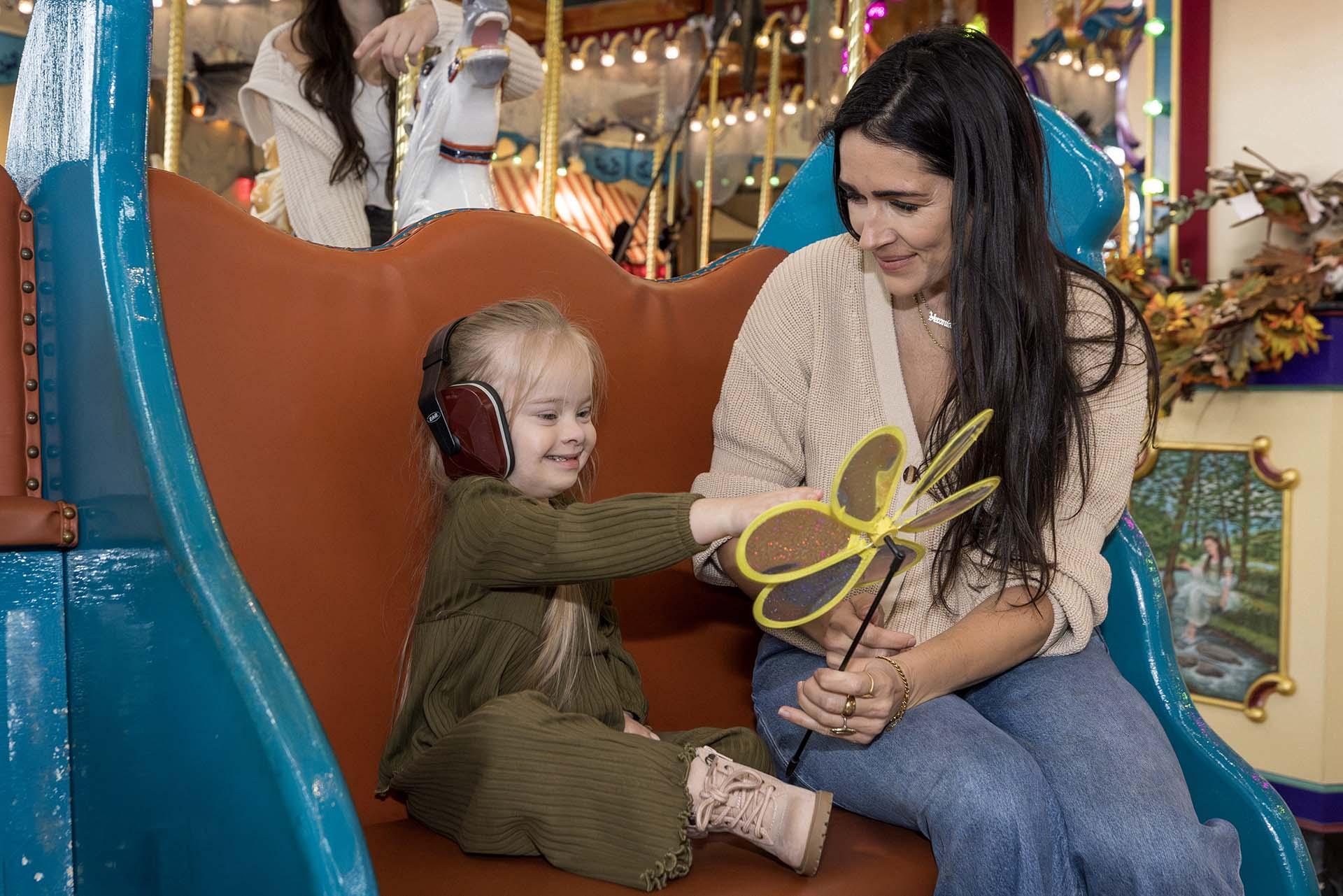 A child and mother riding on the Silver Beach Carousel.