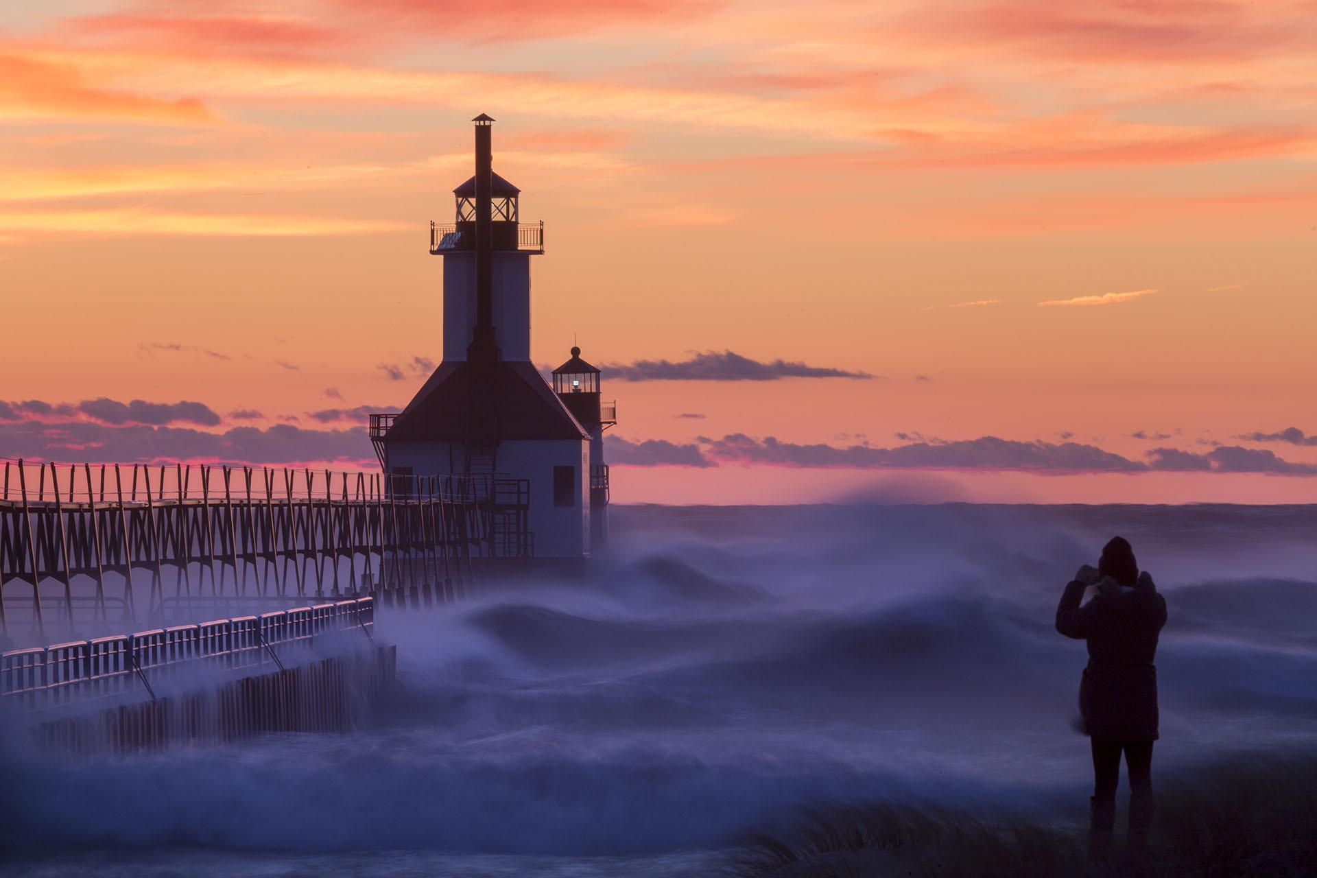 A view of the lighthouse at sunset during a wind storm photo by Joshua Nowicki. 