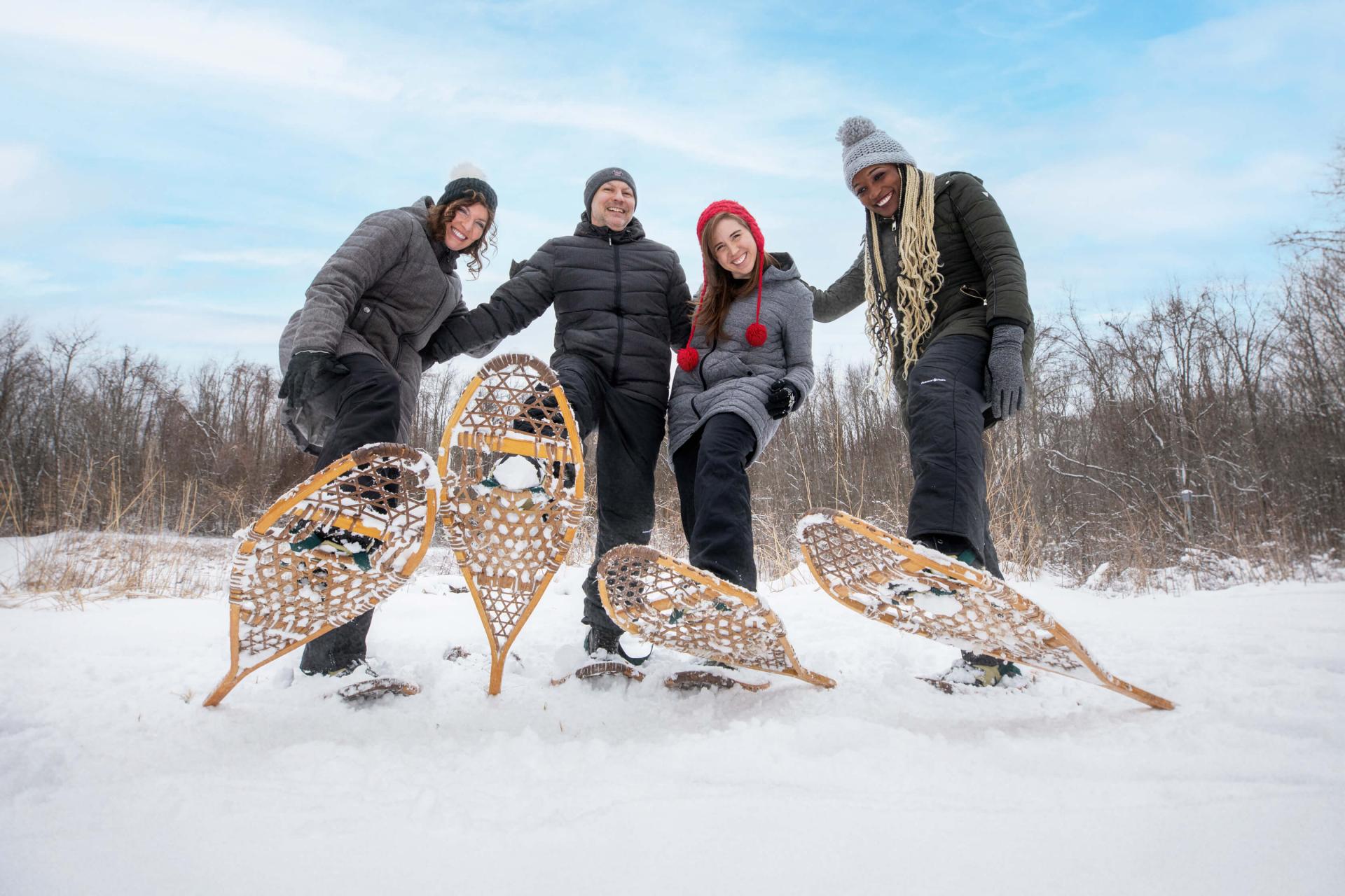 A group of friends snowshoeing in the winter snow.