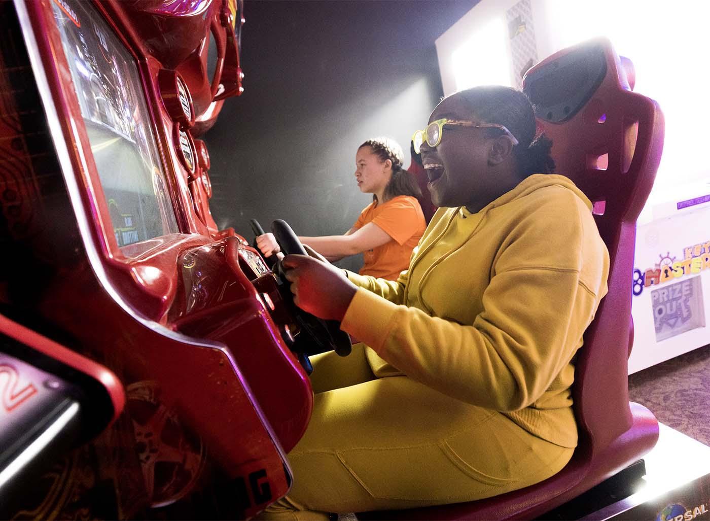 Two people playing arcade games at Slackers.