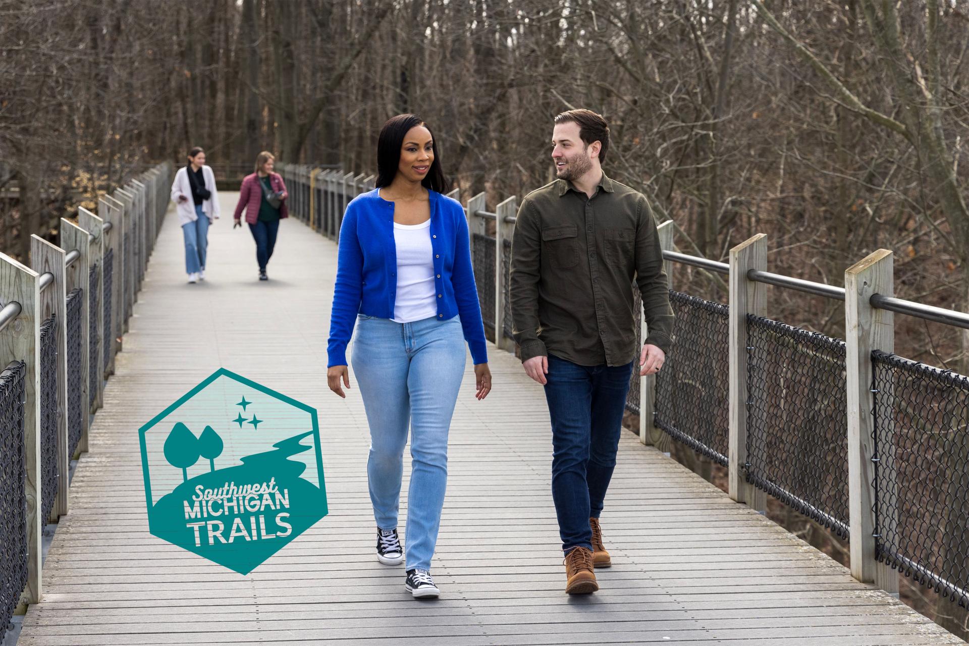 People walking on the catwalk in the Galien River County Park trails.