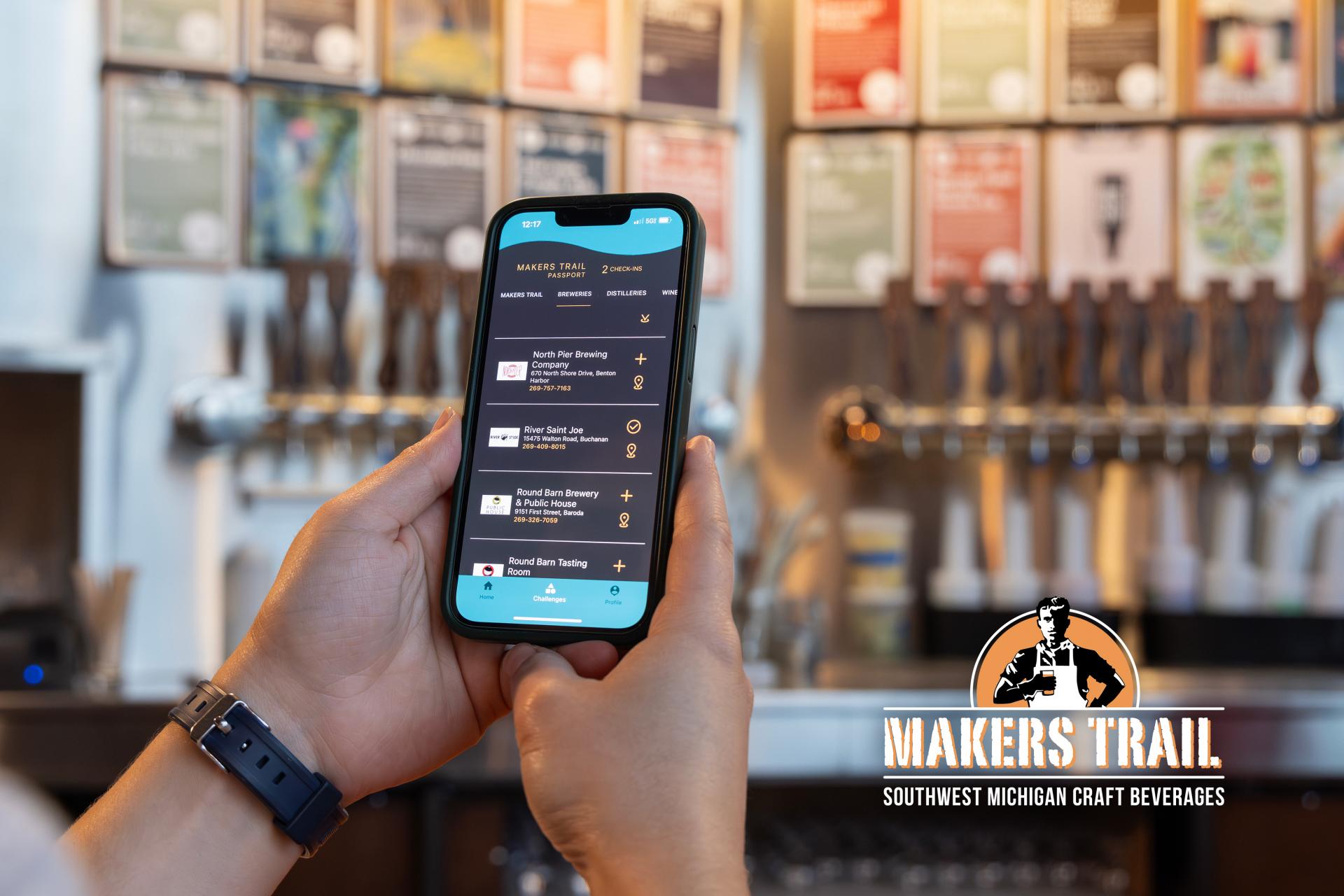 A person interacting with the Visit Southwest Michigan App and checking in to the Makers Trail. 