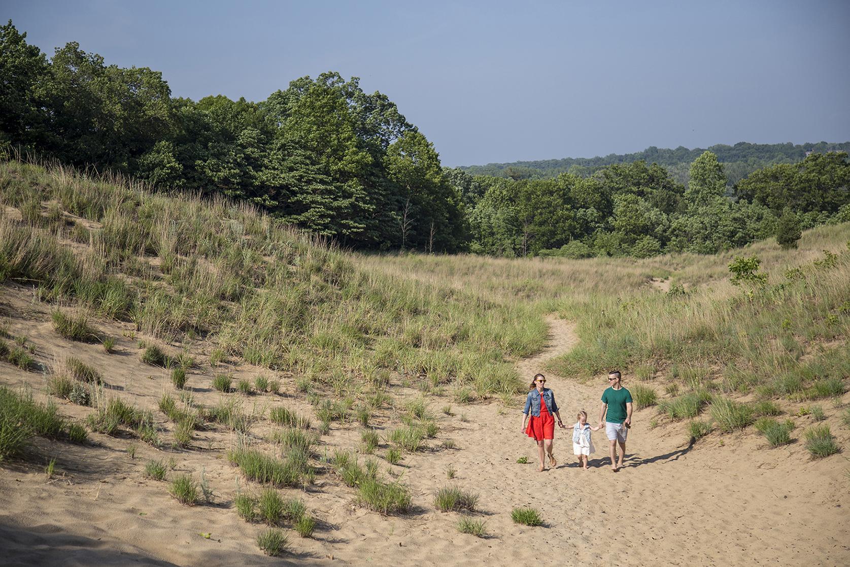 young family walking in the dunes male female child 