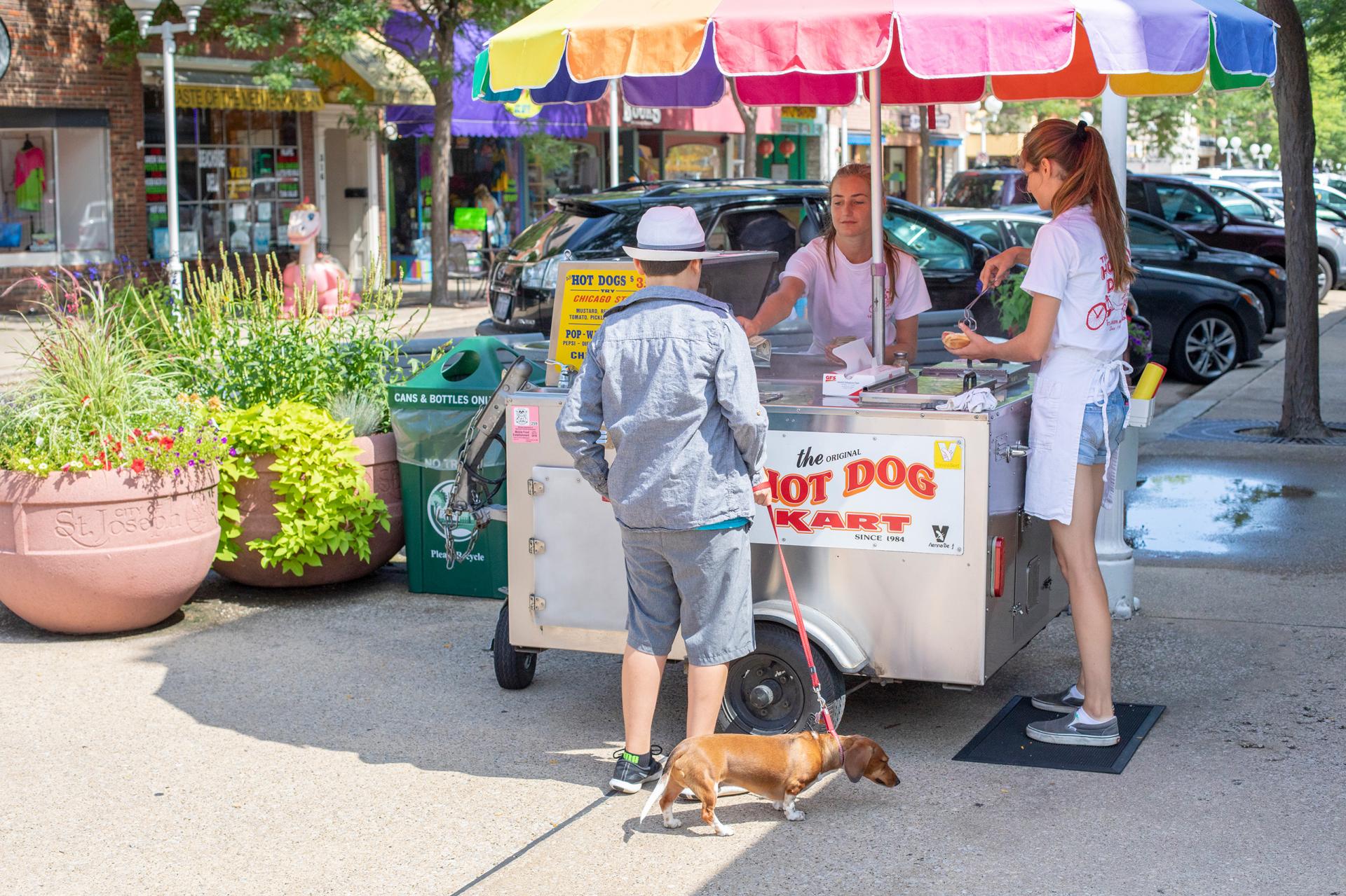 a boy purchasing a hot dog at the hot dog kart st joseph michigan