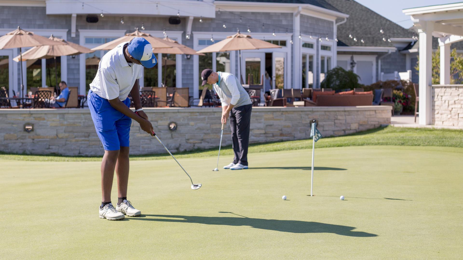 Two men using the putting green at Harbor Shores Golf Course