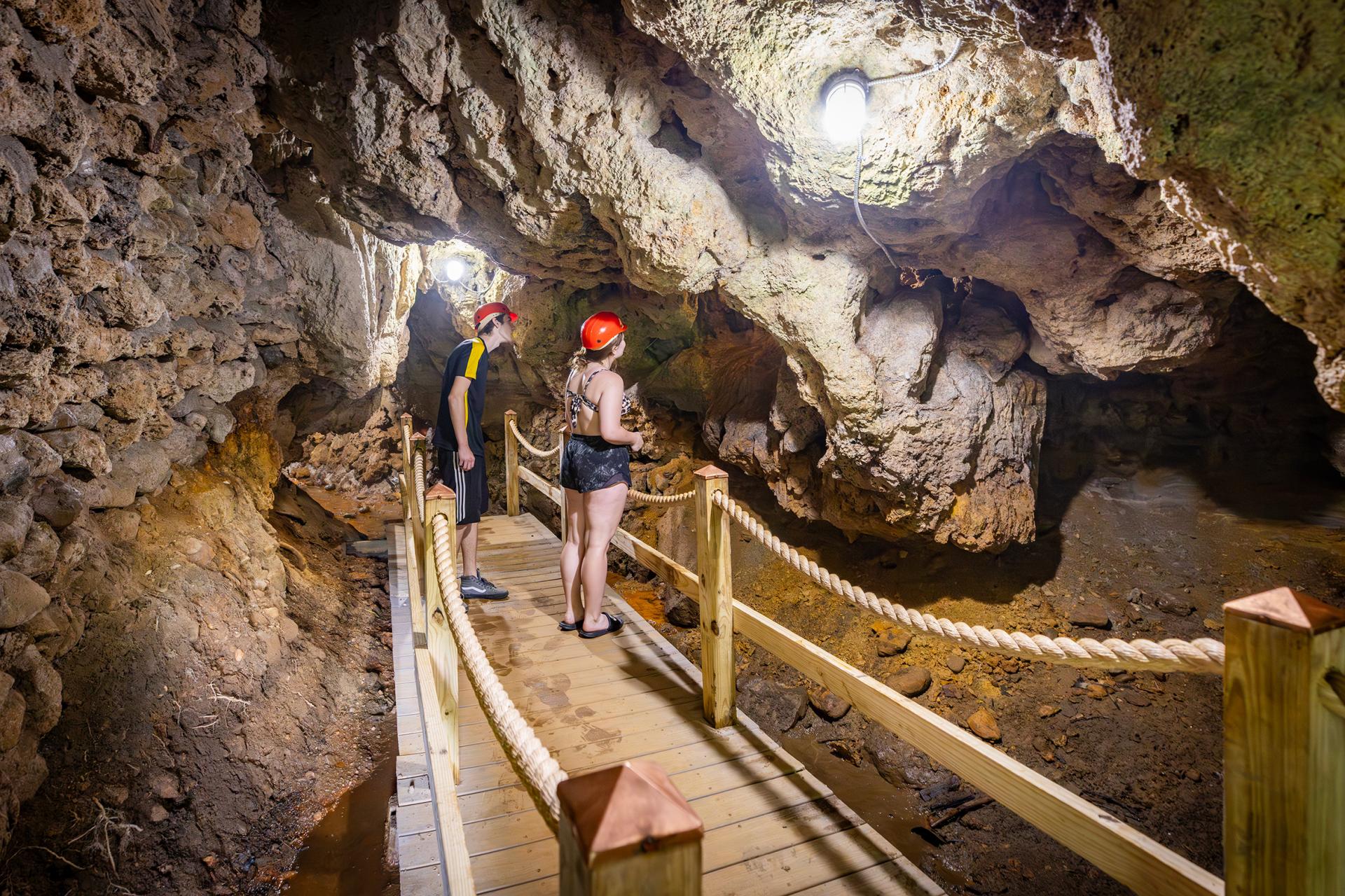Two people looking at rock formations inside Bear Cave in Buchanan